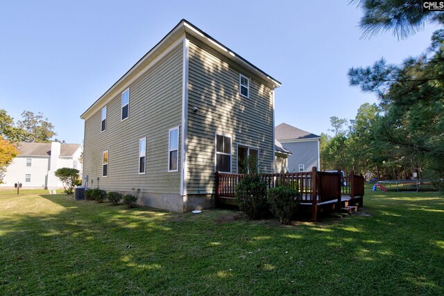 rear view of house featuring cooling unit, a yard, and a deck