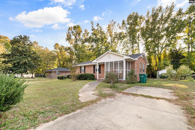 ranch-style home with a sunroom and a front yard