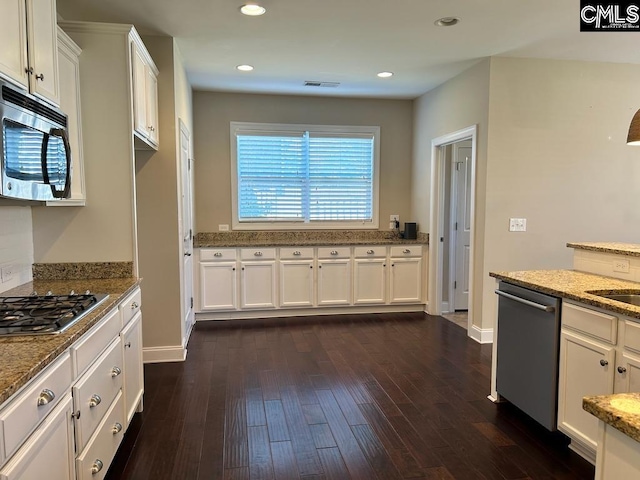 kitchen with light stone counters, stainless steel appliances, dark hardwood / wood-style floors, and white cabinets