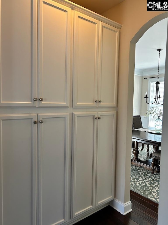 interior space with crown molding, hardwood / wood-style flooring, and a chandelier