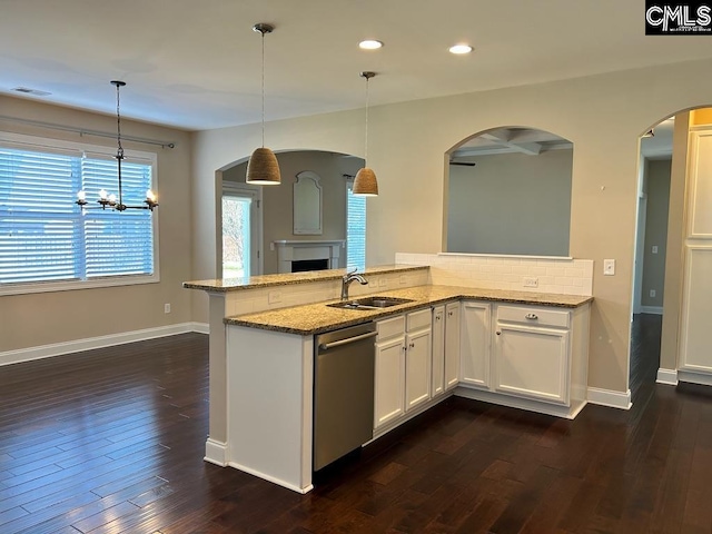 kitchen featuring white cabinetry, light stone countertops, stainless steel dishwasher, pendant lighting, and sink