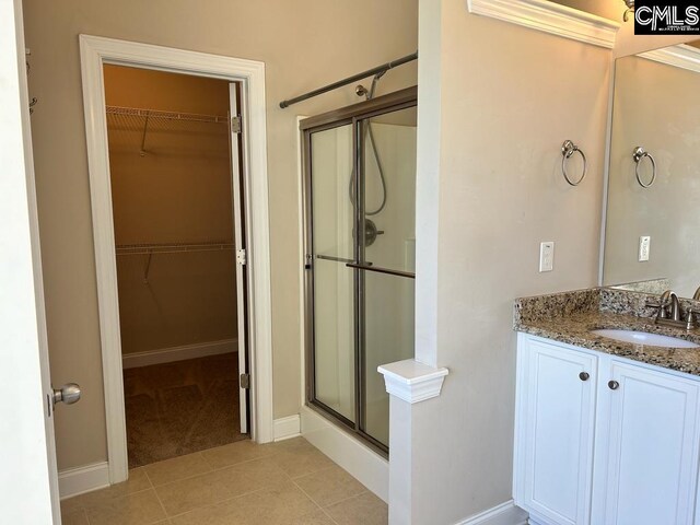 60 Fork Branch Ct, Irmo, SC 29063 - bathroom featuring a spacious closet, tile patterned floors, vanity, baseboards, and a stall shower
