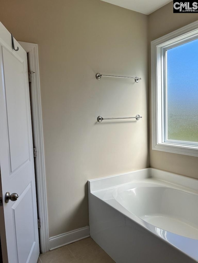 bathroom with a bathtub and tile patterned flooring