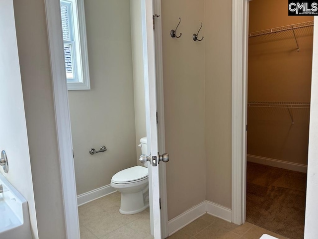 bathroom with toilet and tile patterned flooring