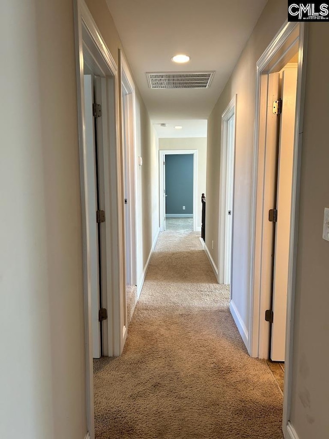 hallway featuring light colored carpet