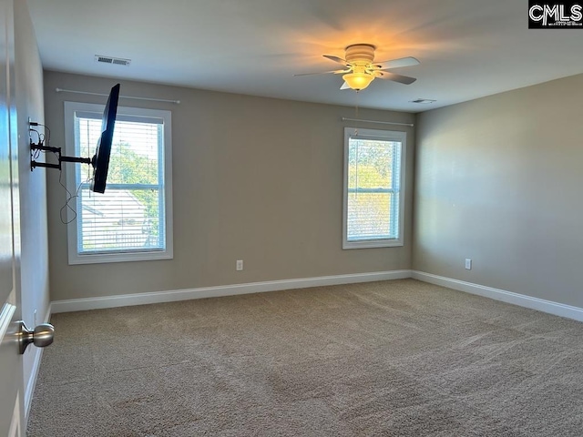 unfurnished room featuring a wealth of natural light, carpet floors, and ceiling fan