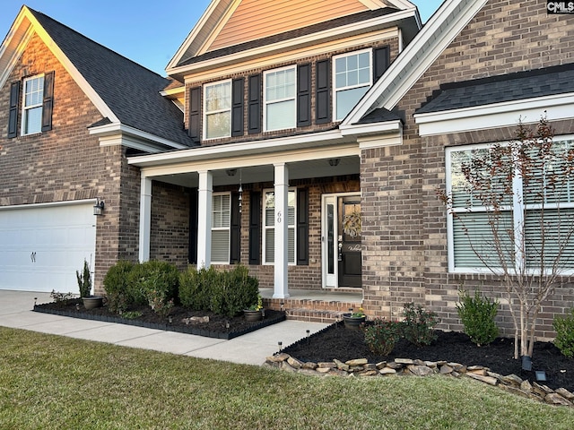 craftsman house with a porch, a front yard, and a garage