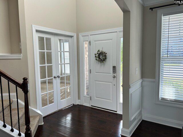 foyer entrance featuring french doors, a wealth of natural light, and dark hardwood / wood-style floors