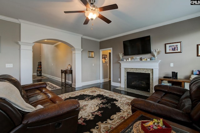 living room featuring ornamental molding, dark hardwood / wood-style floors, ceiling fan, and ornate columns