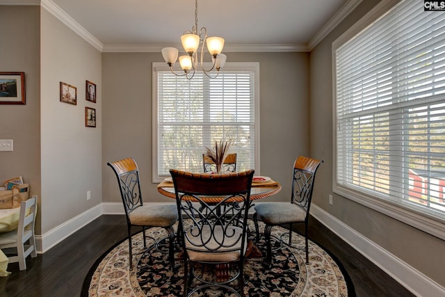 dining room featuring dark wood-type flooring, a chandelier, plenty of natural light, and crown molding