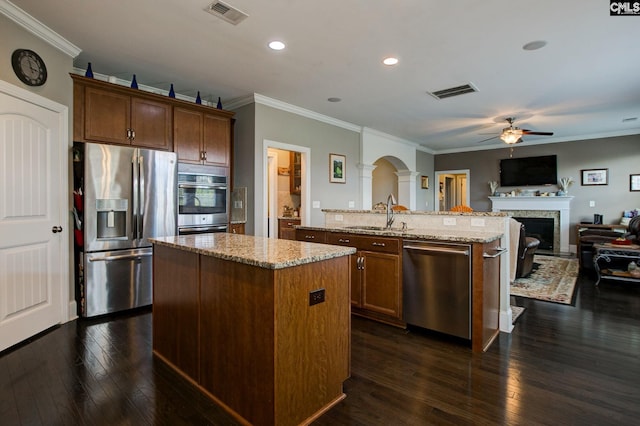 kitchen featuring crown molding, stainless steel appliances, a kitchen island, dark hardwood / wood-style flooring, and sink