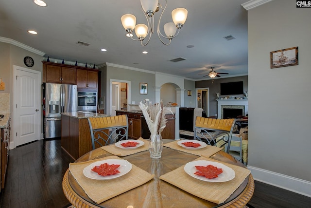 dining space with ceiling fan with notable chandelier, dark hardwood / wood-style floors, and crown molding