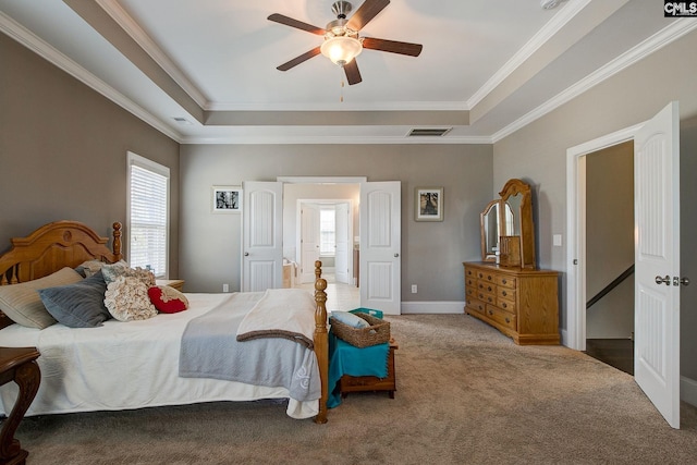 bedroom featuring carpet flooring, ceiling fan, crown molding, and a tray ceiling