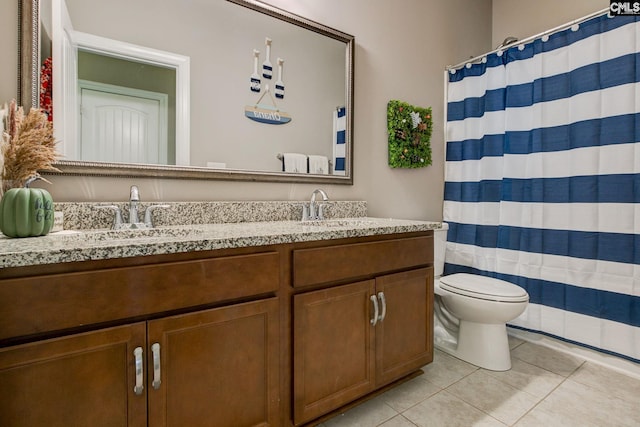 bathroom featuring toilet, vanity, a shower with shower curtain, and tile patterned floors