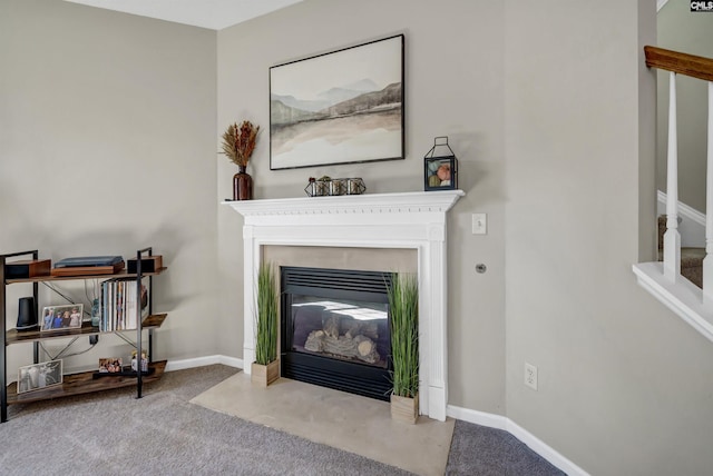 details featuring a fireplace with flush hearth, baseboards, and carpet flooring