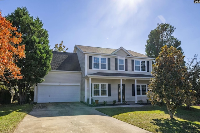 view of front of property with a garage, driveway, a front yard, and covered porch