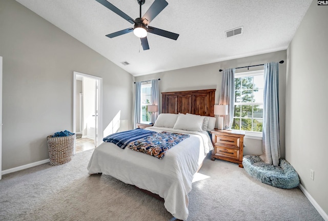 carpeted bedroom with a textured ceiling, ceiling fan, connected bathroom, and vaulted ceiling