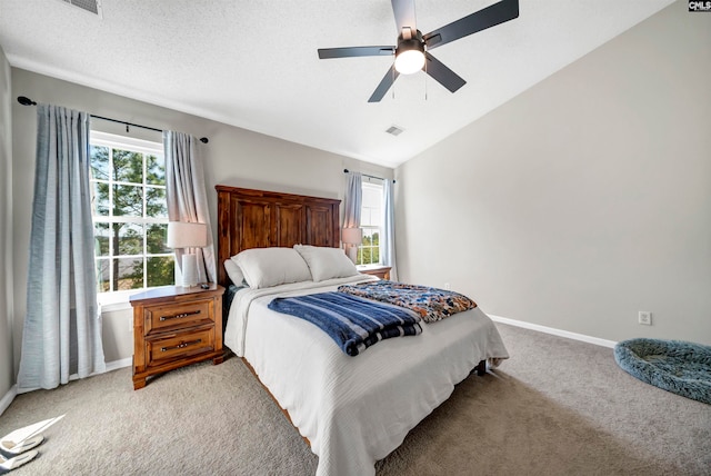 carpeted bedroom featuring ceiling fan, a textured ceiling, and vaulted ceiling