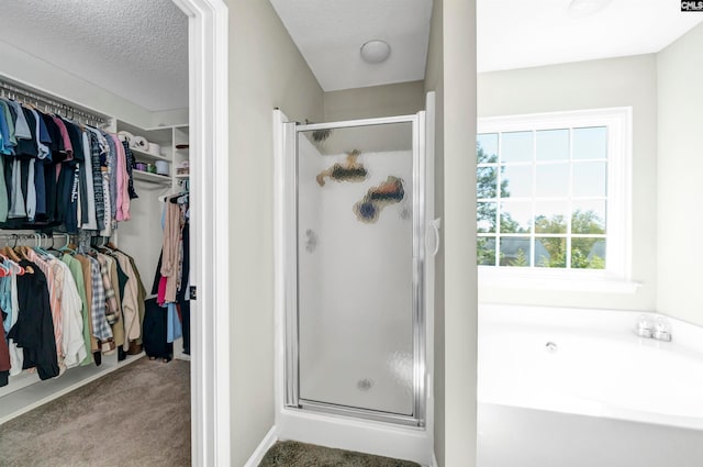 bathroom featuring shower with separate bathtub and a textured ceiling