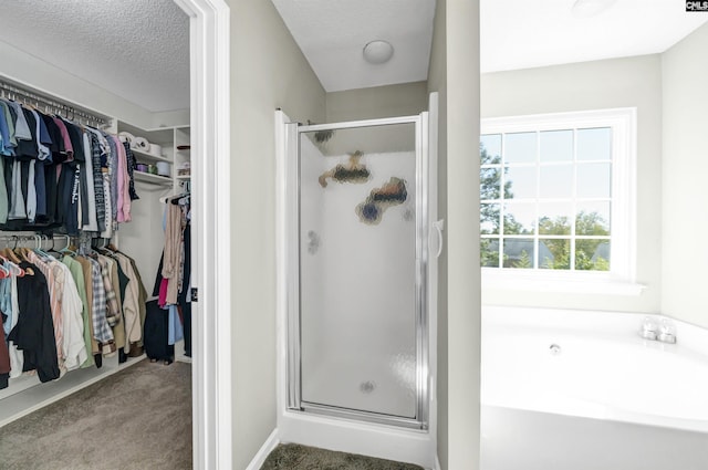 bathroom featuring a spacious closet, a shower stall, and a bath