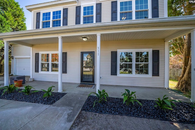 doorway to property featuring covered porch and a garage