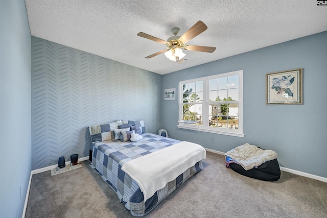 bedroom with a ceiling fan, baseboards, wallpapered walls, and an accent wall