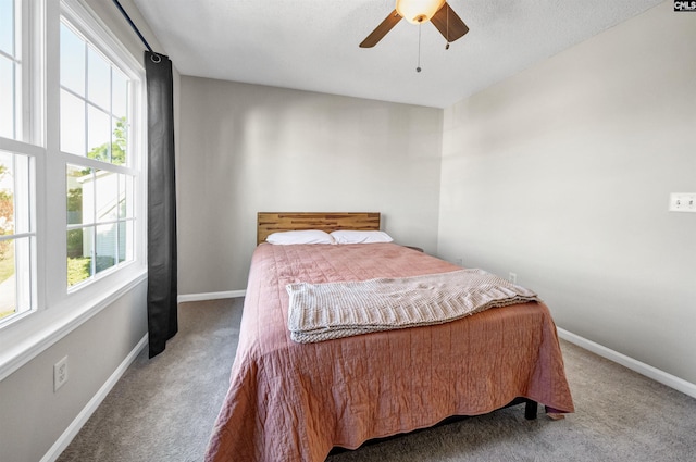 carpeted bedroom featuring baseboards and ceiling fan