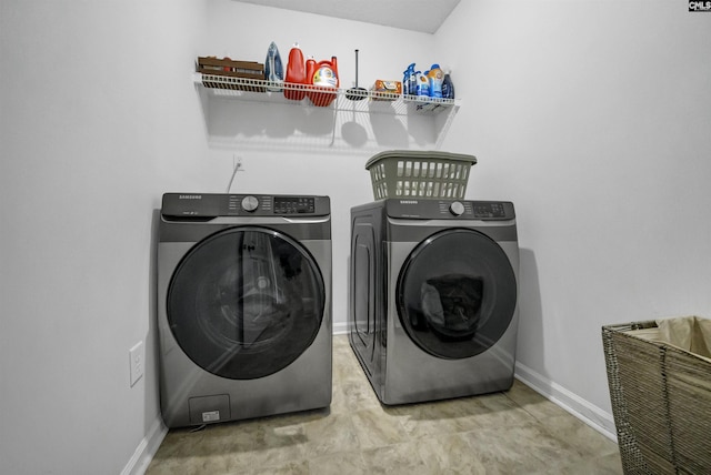 clothes washing area featuring washing machine and clothes dryer, laundry area, and baseboards