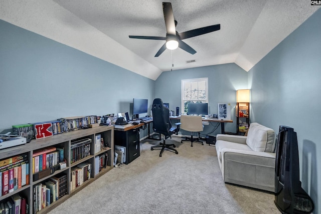 office space featuring visible vents, lofted ceiling, ceiling fan, a textured ceiling, and carpet
