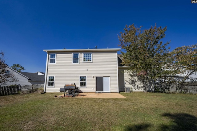 rear view of house featuring a lawn, a fenced backyard, and a patio area