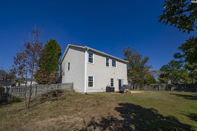 back of house featuring a lawn, a fenced backyard, and a patio area
