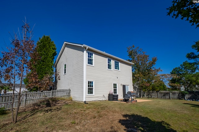 rear view of house with a yard and a patio