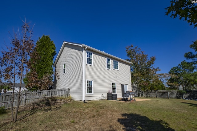 back of house featuring a lawn, a patio, and a fenced backyard