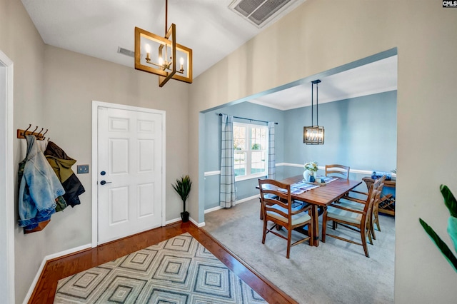 dining area with light hardwood / wood-style flooring and a chandelier