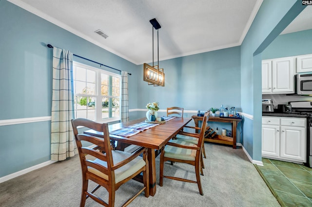 dining area with ornamental molding, a chandelier, and light colored carpet