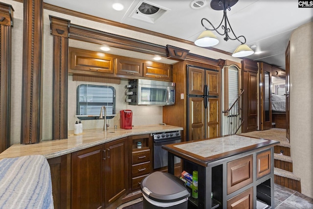 kitchen featuring a kitchen island, black oven, pendant lighting, dark tile patterned flooring, and crown molding