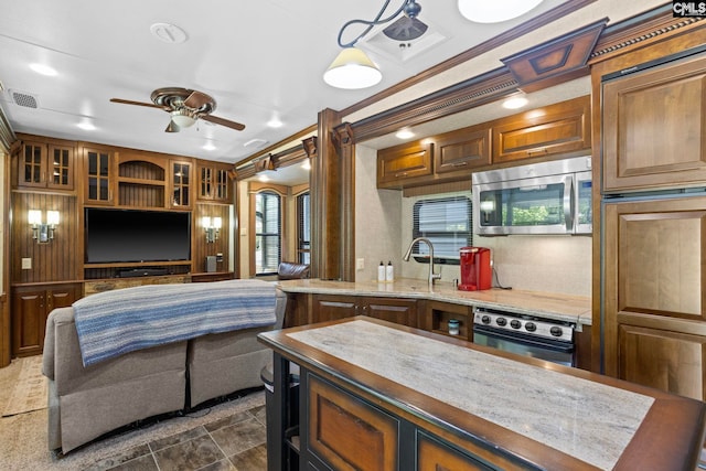 kitchen with appliances with stainless steel finishes, crown molding, sink, and ceiling fan