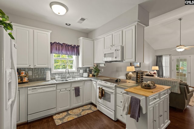 kitchen with white appliances, white cabinetry, and sink