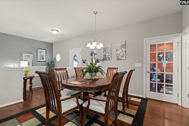 dining space featuring an inviting chandelier and dark hardwood / wood-style floors