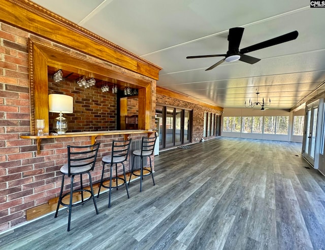 bar with brick wall, dark hardwood / wood-style floors, and ceiling fan