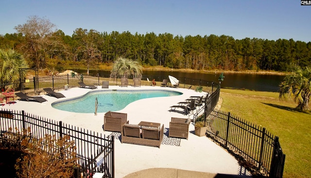 view of pool with a patio, a water view, and a lawn