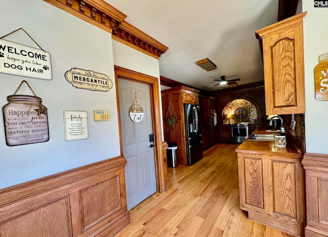 kitchen featuring oven, sink, refrigerator, ceiling fan, and light hardwood / wood-style flooring