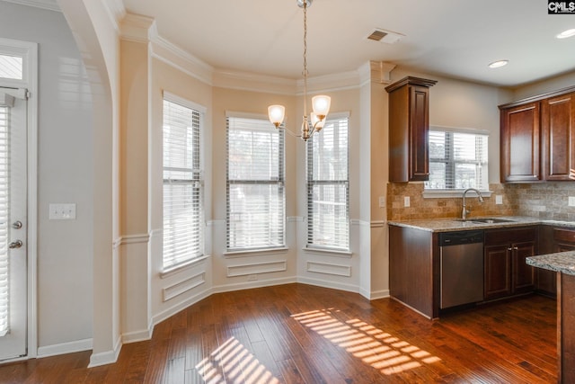 kitchen featuring plenty of natural light, tasteful backsplash, stainless steel dishwasher, and dark hardwood / wood-style floors