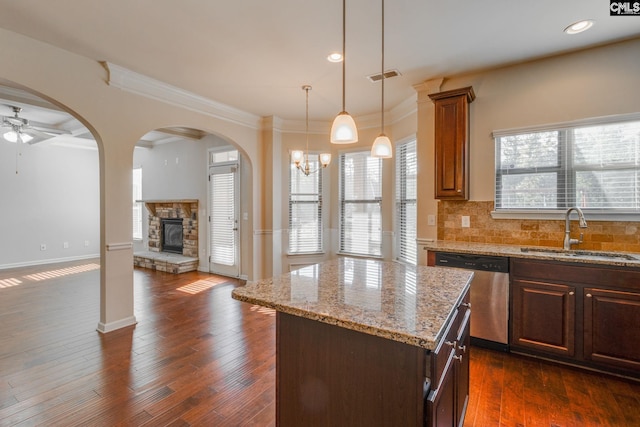 kitchen with sink, dark wood-type flooring, a wealth of natural light, and a kitchen island