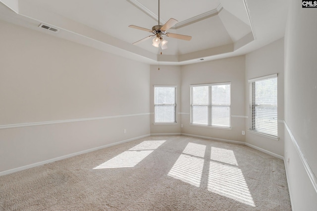 unfurnished room with light carpet, a tray ceiling, and ceiling fan