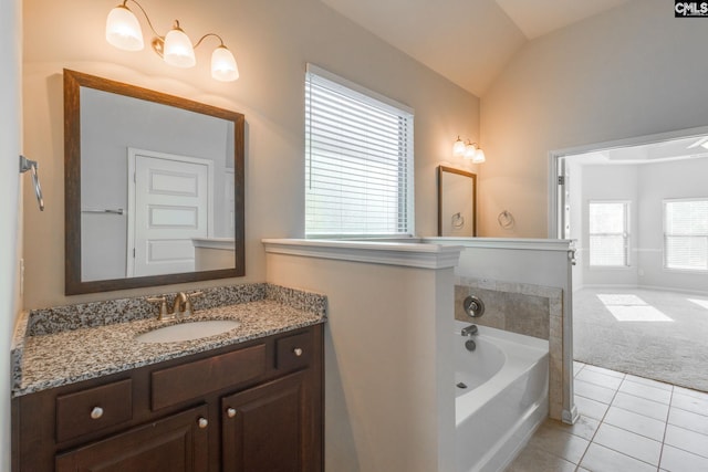 bathroom with vanity, tile patterned flooring, a bath, and vaulted ceiling