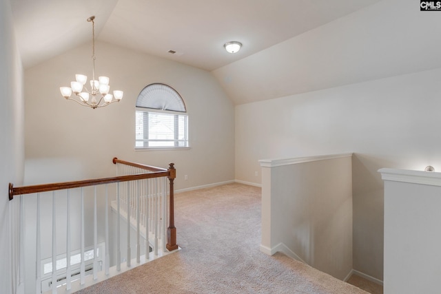 hallway with a notable chandelier, light colored carpet, and vaulted ceiling