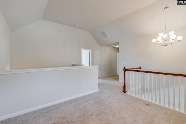 unfurnished room with lofted ceiling, a notable chandelier, and light colored carpet