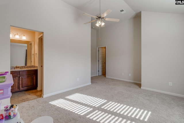 unfurnished bedroom with light carpet, sink, ensuite bathroom, high vaulted ceiling, and ceiling fan