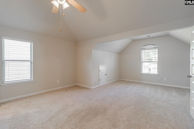 additional living space with ceiling fan, lofted ceiling, and light colored carpet